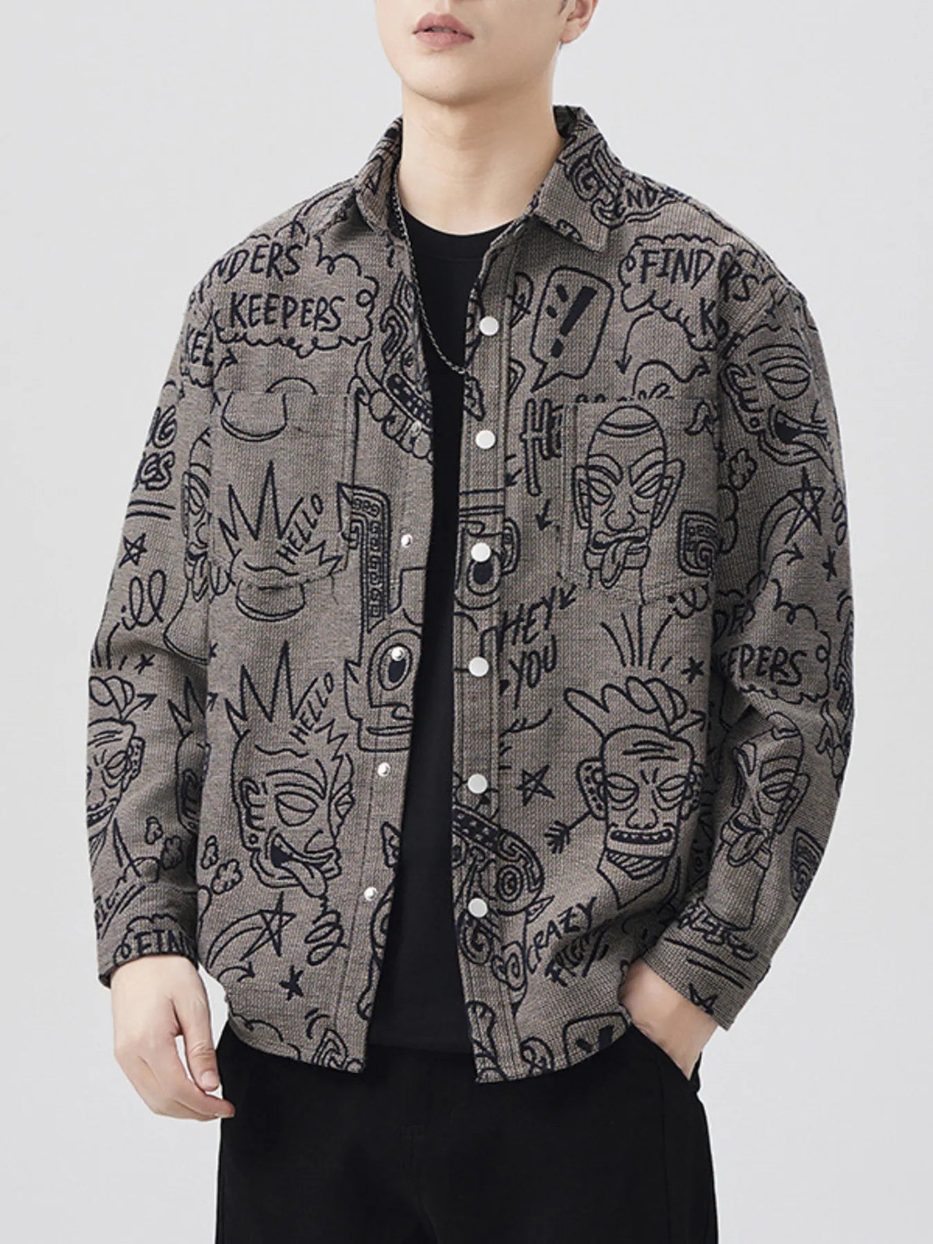 Person wearing a patterned jacket with various designs on a plain background