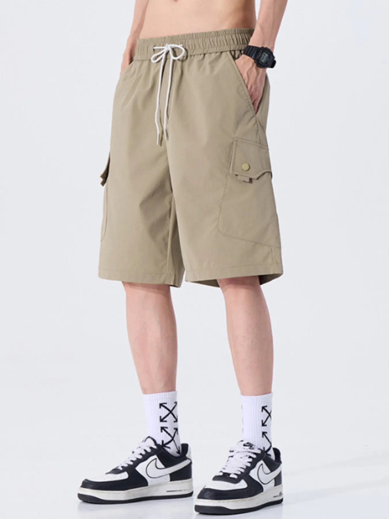 Person wearing beige shorts on a white background