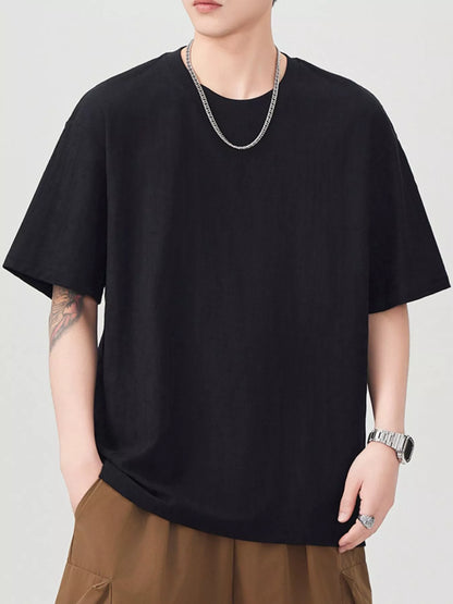 Person wearing a black t-shirt and brown pants on a plain background