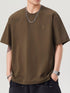 Person wearing a brown t-shirt with a small logo on a plain background