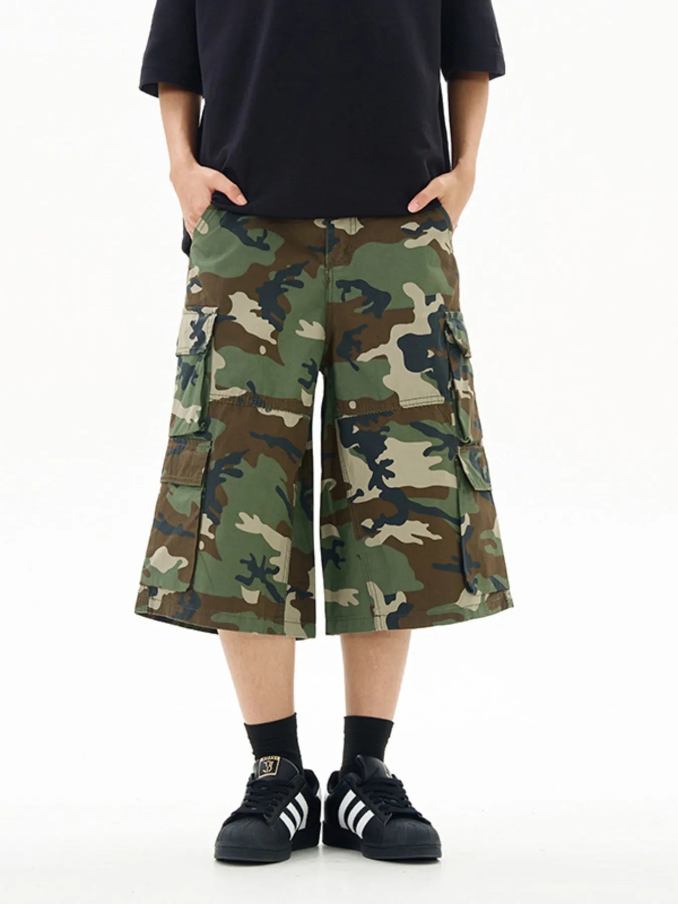 Person wearing camouflage cargo shorts on a white background