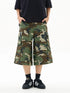 Person wearing camouflage cargo shorts on a white background