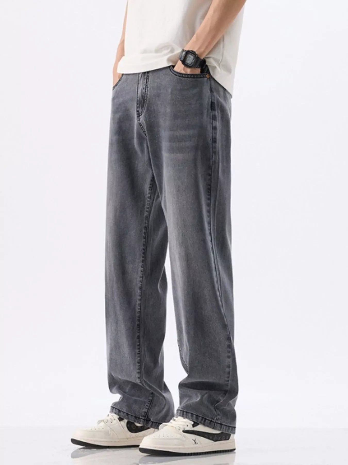 Person wearing gray jeans and a white shirt on a white background